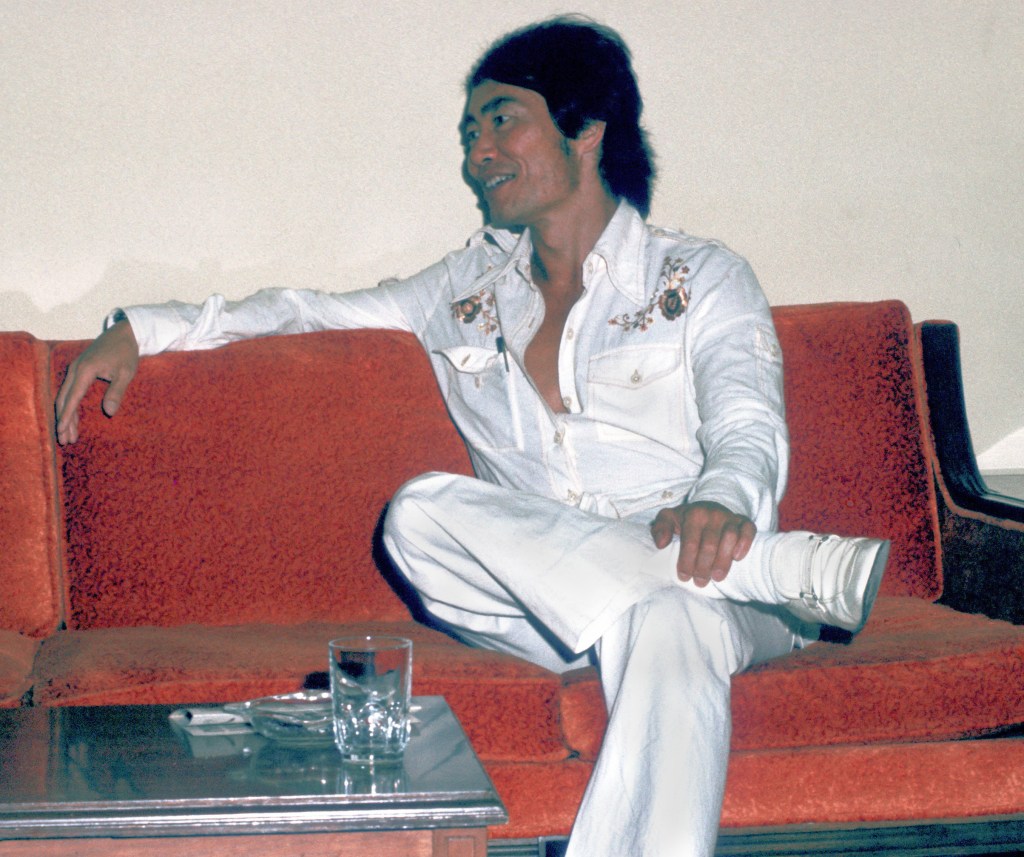 Star Trek actor George Takei relaxing on a couch in the green room. 