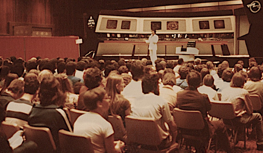 Star Trek actor George Takei on stage before a crowded room.