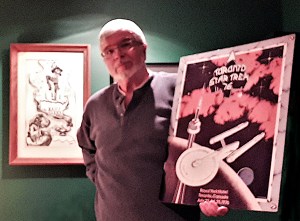 Charlie McKee poses with the poster created for the convention.