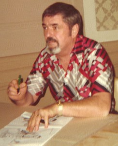 Actor James Doohan signs an autograph, sitting at a table.